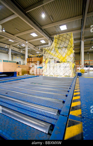 Airfreight moves along a rolling platform ready to be loaded onto aircraft Stock Photo