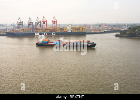 A small to medium size container ship heads out to see along the Elbe, Hamburg Stock Photo