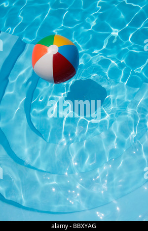 Colorful beachball floating in a blue swimming pool Stock Photo