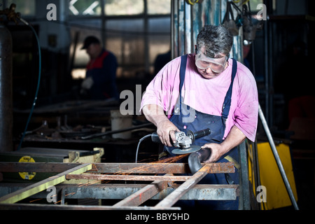 Workman using grinder in workshop Stock Photo