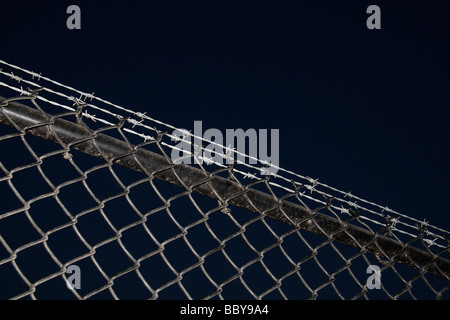 detail of razor wire atop cyclone fence Stock Photo