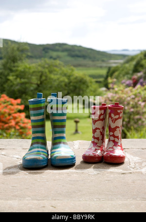 childrens wellington boots on garden steps Stock Photo