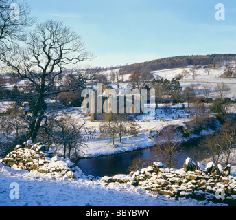 River Wharfe flowing by Bolton Priory surrounded by winter snow by Bolton Abbey Yorkshire Dales UK