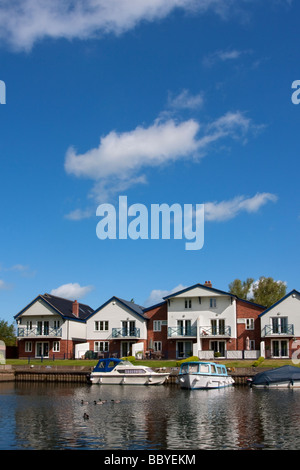 A view of waterside properties and boats at Loddon on a Spring / Summer morning on the Norfolk Broads Stock Photo