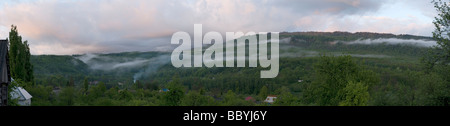 Misty sunset over a remote & small mountain village. Stock Photo