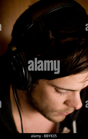 Young man listening to music on headphones Stock Photo