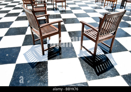 Wooden chairs on black and white floor Stock Photo