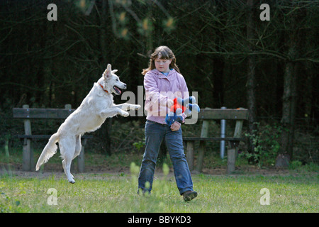 a young girl teaching her golden retriever tricks Stock Photo