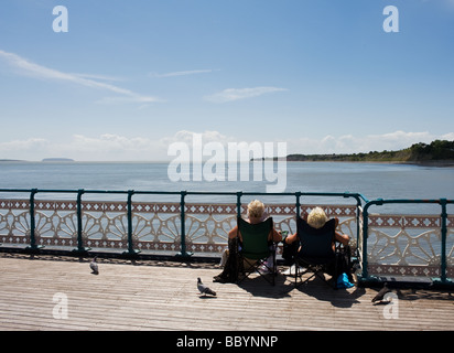 Two people sunbathing on Penarth Pier in South Wales.  Photo by Gordon Scammell Stock Photo