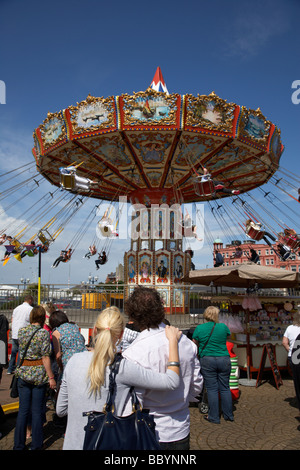 couple standing watching chair o plane fairground funfair ride bangor county down northern ireland uk Stock Photo