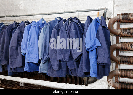 Blue work clothing hanging on a pole, former locker room for workers, Hendrichs swage forge, LVR Industrial Museum, Solingen, N Stock Photo