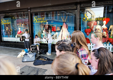 Girls watching young boys busking on a Dublin street Republic of Ireland Stock Photo