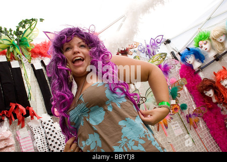 two girls at Womad Festival trying on colourful wigs Stock Photo
