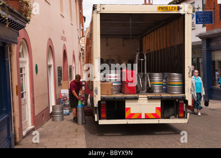 A male man worker unloading beer barrels from the back of a lorry in a uk street Stock Photo