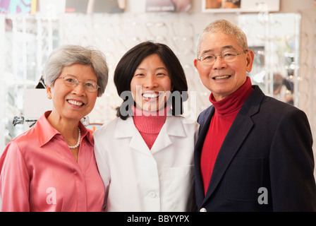 Korean optician standing with customers Stock Photo