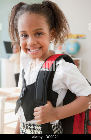 Happy girl posing with backpack carrying books Stock Photo - Alamy
