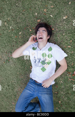 Chinese man laughing and using cell phone Stock Photo