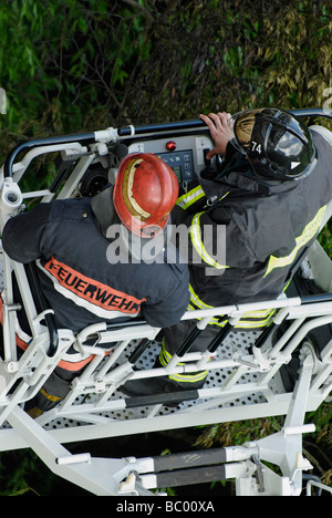 Two firemen in aerial platform of fire engine Stock Photo