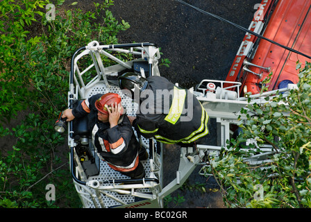 Two firemen in aerial platform of fire engine Stock Photo