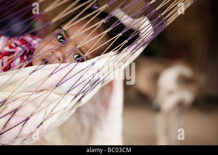 A small girl in a hammock in the community of Charco Redondo, Oaxaca, Mexico. Stock Photo
