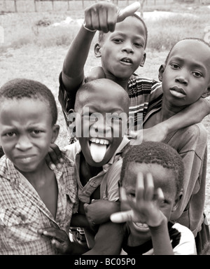 Black and white photograph of Gambian African boys pulling faces and messing about for the camera
