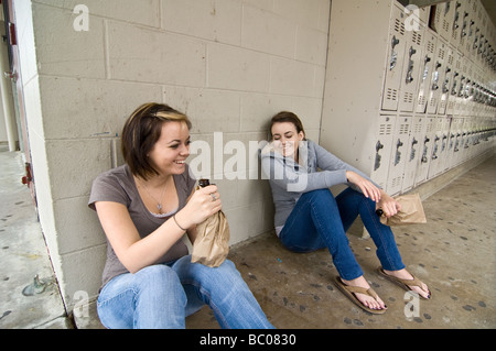 Twins girls getting drunk drinking alcohol at their high school Stock Photo