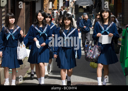 A group of high school girls wearing sailor uniforms enjoying a stroll along a street in Takayama during their school trip Stock Photo