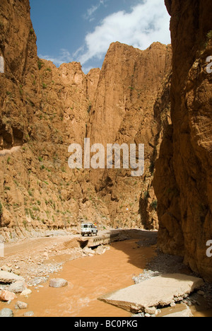 A Land Rover stands amid the soaring walls of the valley in the Todra Gorge after heavy rainfall Morocco North Africa Stock Photo