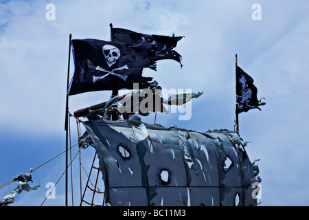 pirate flags above tattered sails Stock Photo