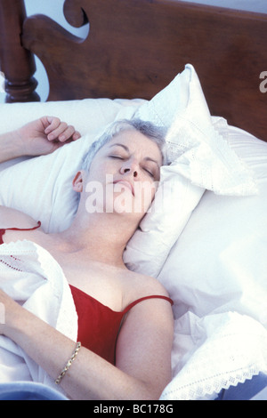 Mature woman sleeping on the bed Stock Photo - Alamy