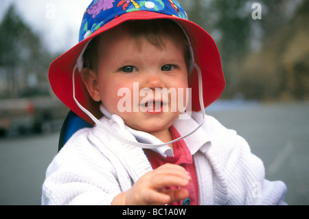 An 18 month old infant human infant baby wearing a rain hat Stock Photo