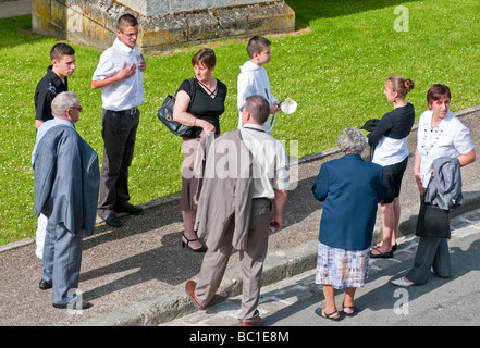Group of nine people gathering before Sunday Mass in church - France. Stock Photo