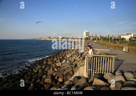 Woman standing on boardwalk by the sea, New Plymouth, New Zealand Stock Photo