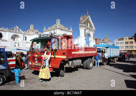 Aymara couple decorating their truck outside the cathedral before a blessing ceremony, Copacabana, Bolivia Stock Photo