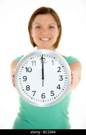 Woman Holding Clock Showing 12 O'Clock Stock Photo