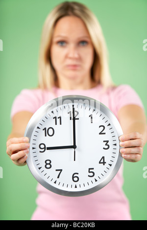 Woman Holding Clock Showing 9 O'Clock Stock Photo