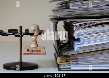 Stamp with inscription next to a pile of files Stock Photo