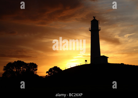 Silhouette of lighthouse at sunset Stock Photo