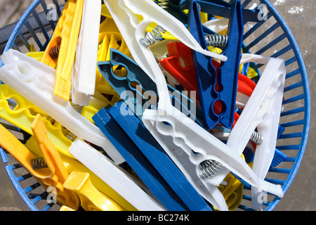Cheap plastic clothes pegs in plastic basket Stock Photo