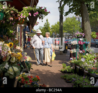 A mature couple walk hand in hand along Clifton Street, Lytham St Annes Stock Photo