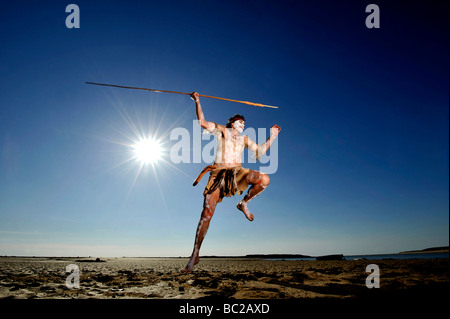 Budawang elder Noel Butler 59 from New South Wales Australia performs an aboriginal fishing dance against a blue sky Stock Photo