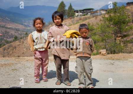 3 young children by side of road in Bhutanese mountains, Asia  91454 Bhutan-Tibetan Stock Photo