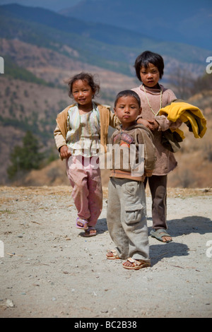 3 young children by side of road in Bhutanese mountains, Asia  91455 Bhutan-Tibetan Stock Photo