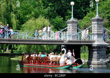 Swan boat passing under foot bridge in Boston Public Gardens located adjacent to the Boston Common Boston, MA USA Stock Photo