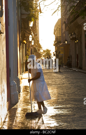 Early morning street scene, Old Havana, Cuba. Washing the strry in front of a building. Stock Photo