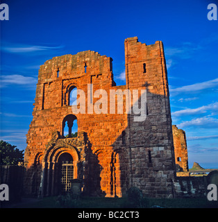 Lindisfarne Priory on Holy Island with Lindisfarne Castle on the horizon in early morning light Stock Photo