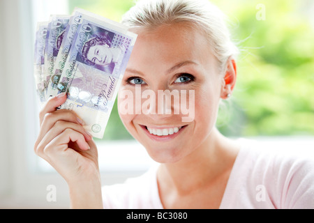 Woman holding 20 pound notes Stock Photo