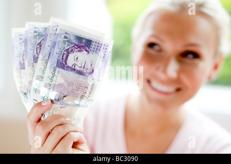 Woman holding 20 pound notes Stock Photo