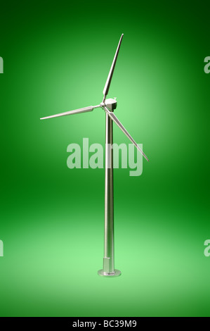 A small metal wind turbine on a green background Stock Photo