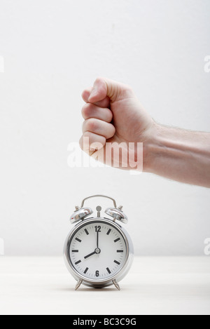 Man about to destroy an alarm clock Stock Photo